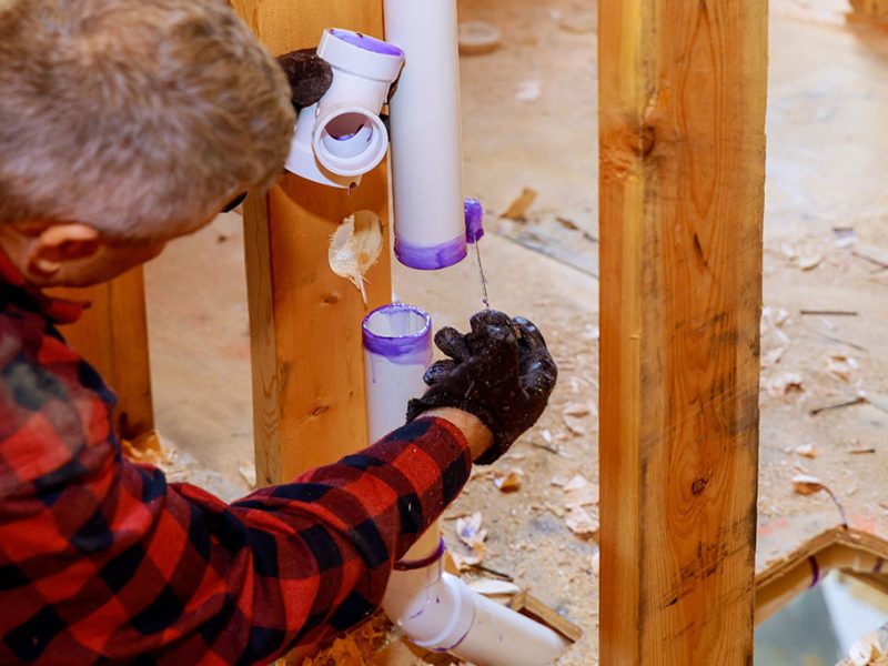 Plumber assembling and glue pvc drain pipes. Water Pipe and Drain Pipe Leak Repairs in Glenview IL with JPW Plumbing